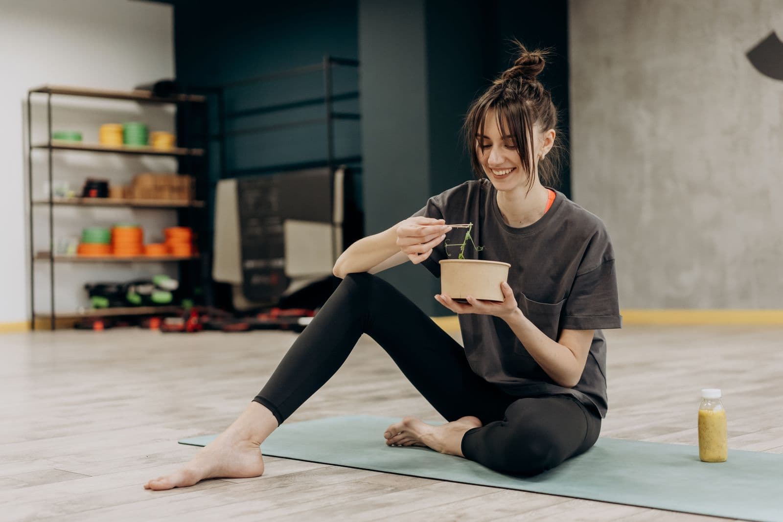 A woman eating a salad after exercising. Photo by Mikhail Nilov on Pexels.