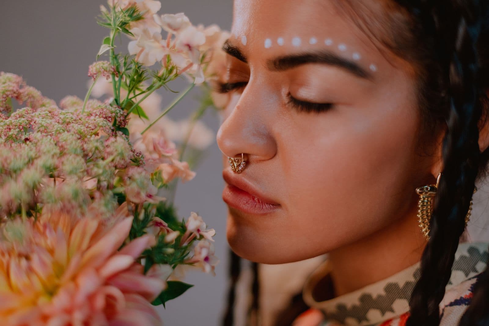 A woman with her eyes closed holding a bouquet of flowers to her face. Photo by cottonbro studio on Pexels.
