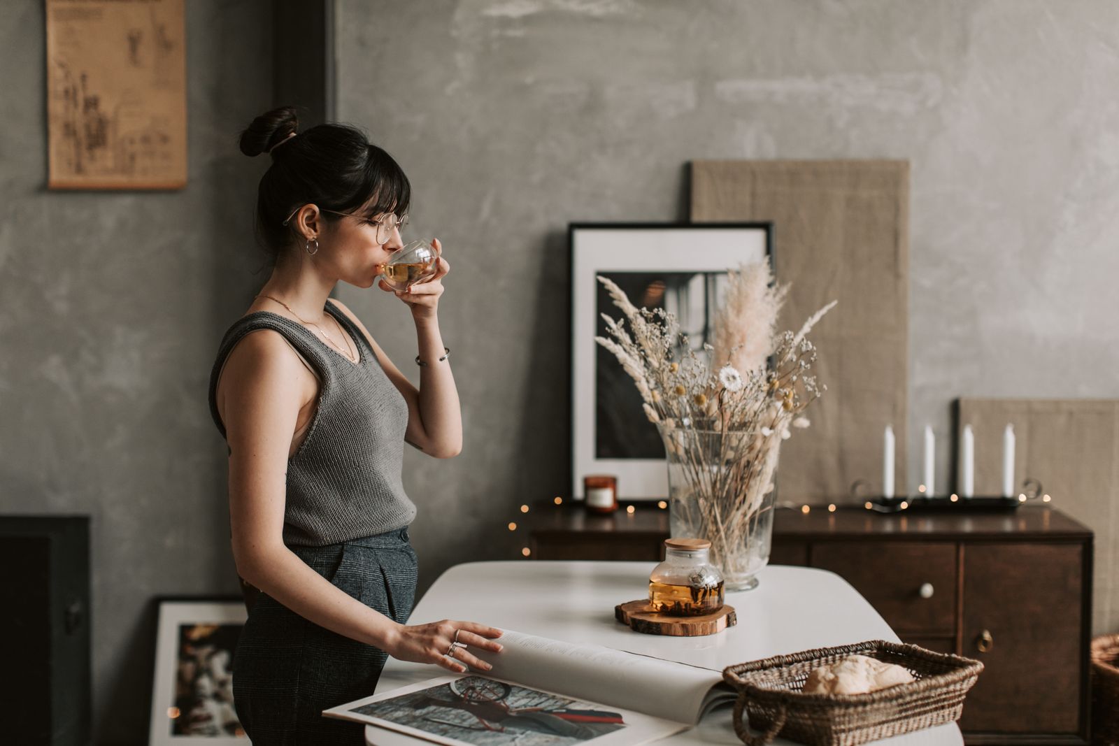 Woman in a warm, softly lit room enjoying a cup of tea