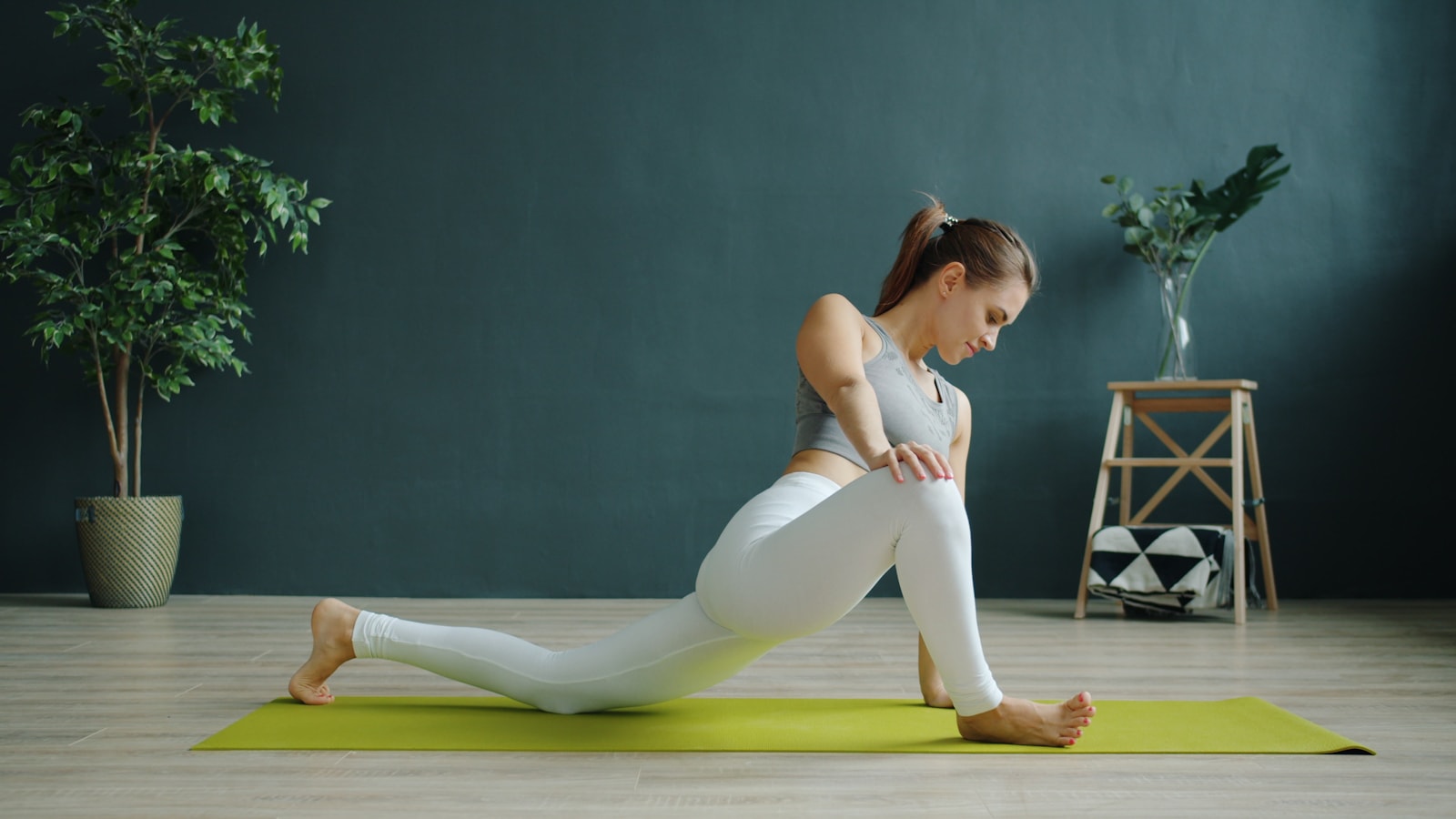 A woman stretching on a yoga mat in a calm indoor studio